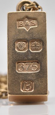 Lot 465 - A 9ct yellow gold ingot pendant, suspended on...