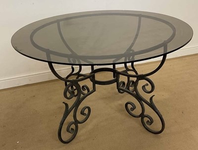 Lot 746 - An ornate metal worked table with smoked glass...