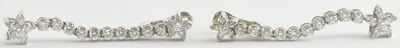 Lot 1442 - A pair of white metal diamond set floral drop...