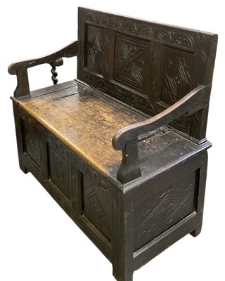 Lot 30 - An 18th century carved oak settle, with hinged...