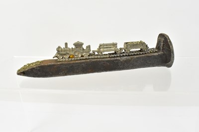 Lot 733 - A railway sleeper spike, adorned with a small...