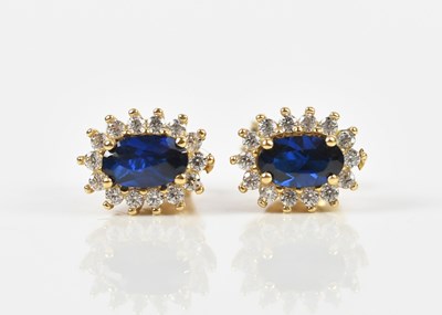 Lot 1404 - A pair of yellow metal ear studs set with oval...