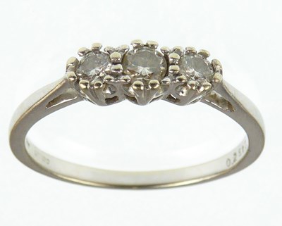 Lot 1003 - An 18ct white gold three-stone diamond ring,...