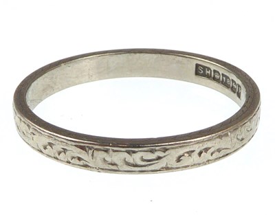 Lot 993 - An 18ct white gold wedding band with Celtic...