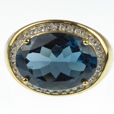 Lot 1044 - A 9ct gold diamond and blue stone ring with...