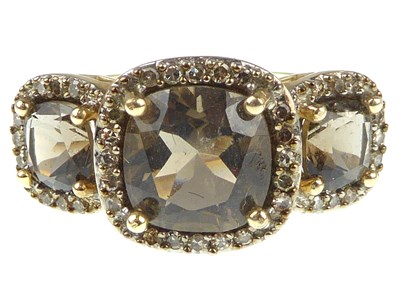 Lot 1045 - A 9ct gold dress ring, three graduated smoky...