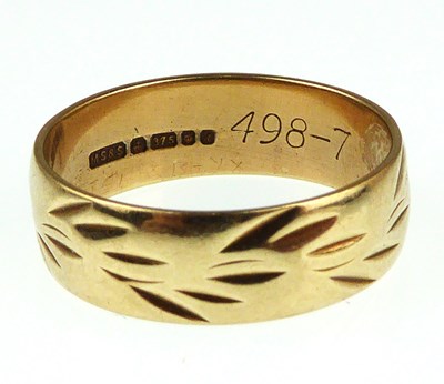 Lot 1074 - A 9ct gold wedding band with floral decoration,...