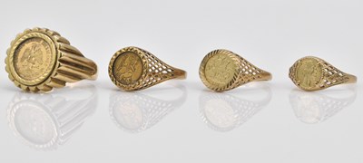 Lot 1056 - Four 9ct gold coin/token set rings, combined...