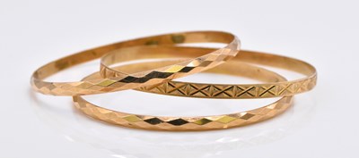 Lot 1074 - Three 14ct gold bangles, combined approx 20g.