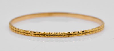 Lot 1076 - A yellow metal bangle, stamped 18k, approx 11.2g.