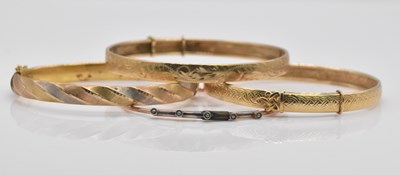 Lot 1078 - Four 9ct gold bangles, combined approx 26.3g.