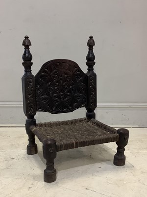 Lot 1522 - A carved hardwood Nuristan low chair, with...