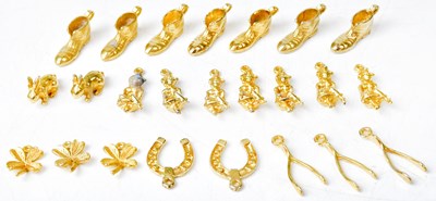 Lot 1123 - Twenty-four gold-coloured metal charms,...