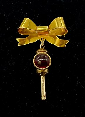 Lot 906 - A 9ct gold bow brooch suspending a 9ct gold...