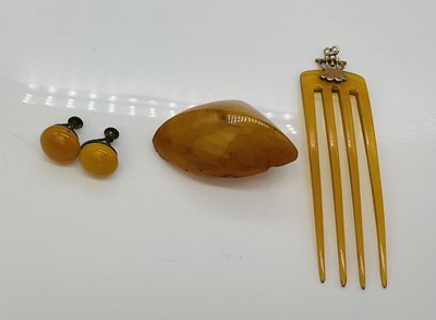 Lot 957 - An amber coloured comb with screw yellow metal...