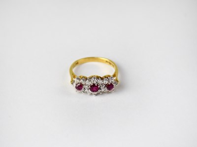 Lot 1023 - An 18ct gold ring set with three clusters of...