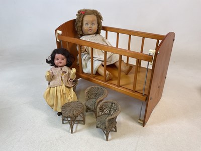 Lot 2009 - A small crib and two dolls, 43 x 57 x 30cm,...