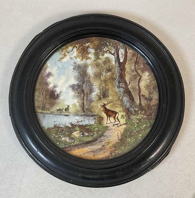 Lot 2326 - A painted porcelain charger, a woodland scene...