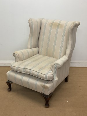 Lot 2812 - An upholstered wingback armchair with mahogany...