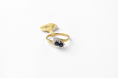 Lot 1056 - A 9ct gold ring set with a pair of sapphires...