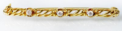 Lot 1090 - A 9ct yellow gold bar brooch set with three...