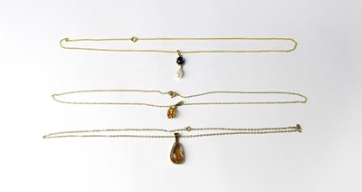 Lot 1172 - Three 9ct gold pendants, each set with...