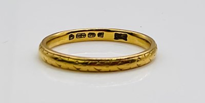 Lot 654 - A 22ct engraved yellow gold wedding band, size...