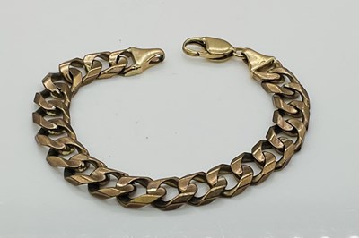 Lot 673 - A heavy 9ct yellow gold curb link bracelet,...