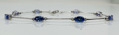 Lot 635 - A 14ct white gold and tanzanite line bracelet,...