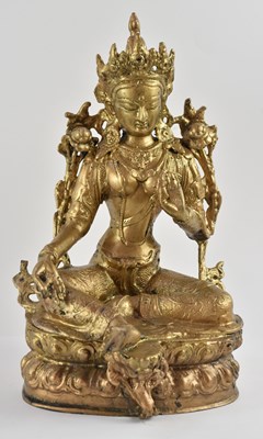 Lot 1051 - A Tibetan gilt decorated white metal figure of...