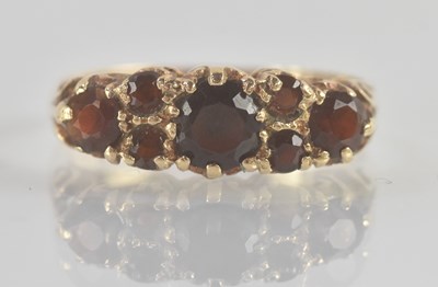 Lot 1252 - A 9ct yellow gold three stone garnet set ring,...