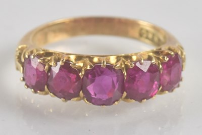 Lot 1205 - A 9ct yellow gold ruby five stone ring, the...