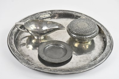 Lot 1215 - HUGH WALLIS; a hammered pewter sauce boat,...