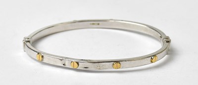 Lot 1061 - A 9ct white gold hinged bangle with...