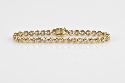 Lot 1161 - A 9ct yellow gold tennis bracelet, set with...