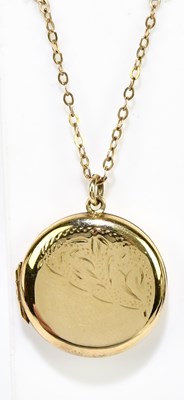 Lot 1401 - A 9ct yellow gold chain suspending a circular...
