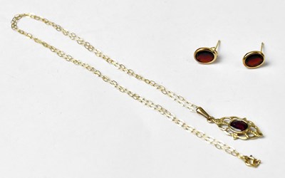 Lot 1125 - A yellow metal pendant set with an oval garnet,...
