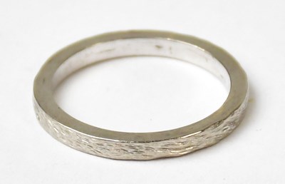 Lot 994 - An 18ct white gold wedding ring with a bark...