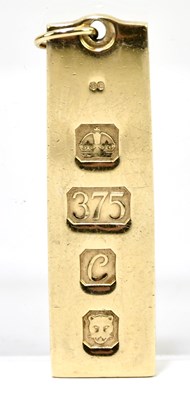 Lot 1344 - A 9ct yellow gold rectangular ingot pendant,...