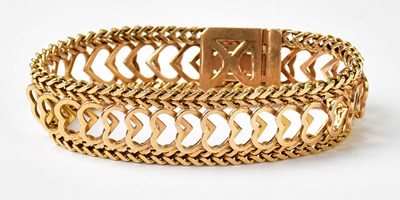 Lot 1064 - A yellow metal bracelet with heart-shaped...