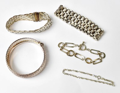Lot 1069 - Five silver bracelets, comprising a wide...