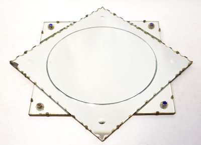 Lot 75 - A 1940s shaped wall mirror, set with blue cut...
