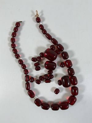 Lot 651 - A quantity of cherry amber beads, some formed...