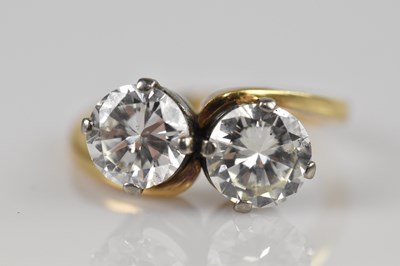 Lot 2239 - A yellow metal diamond two stone twist ring,...