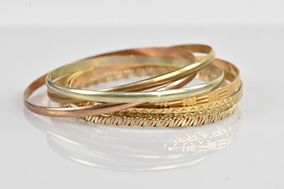 Lot 1154 - Two 9ct gold bangles, a 9ct tri-colour gold...