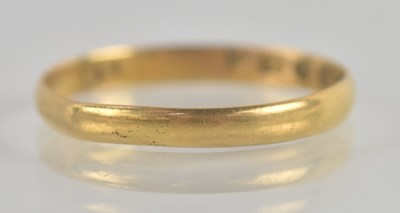 Lot 1343 - A 22ct yellow gold thin band ring, size O,...