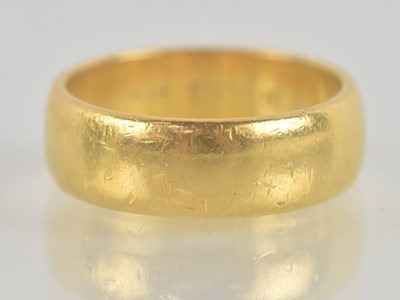 Lot 1312 - A 22ct yellow gold band ring, with worn...