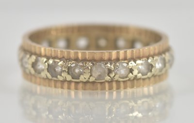 Lot 1347 - A gold coloured metal band/eternity ring, with...