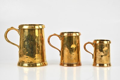 Lot 1169 - Three 19th century brass measuring mugs,...