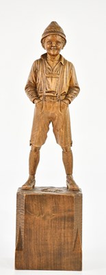 Lot 1114 - A carved Black Forest figure of a boy wearing...